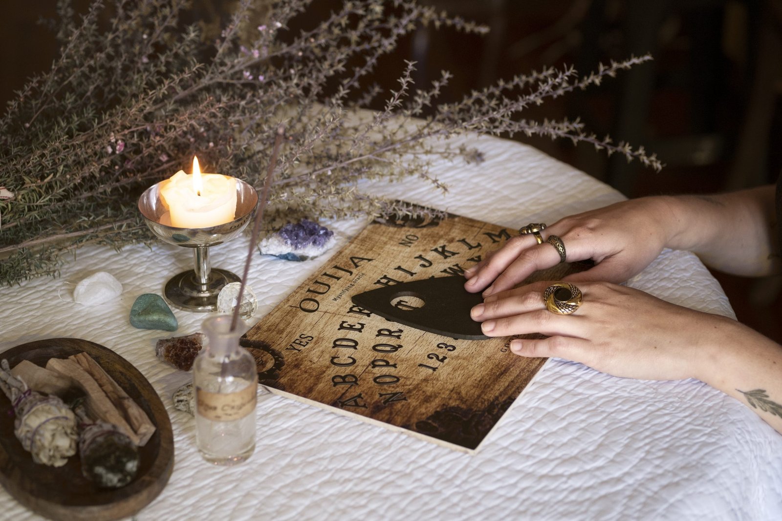 hands-using-old-wooden-ouija-board-side-view